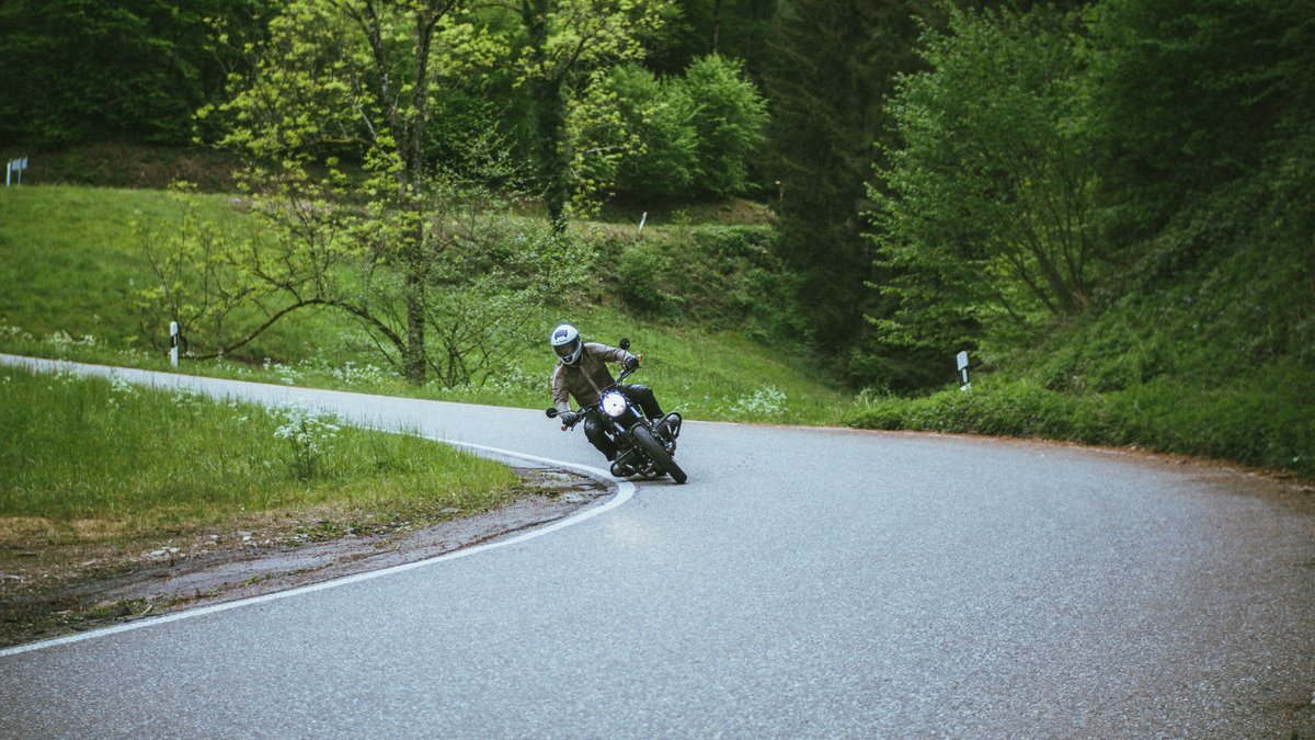 Motorradfahrer in Schräglage auf Kurvenstraße im Schwarzwald